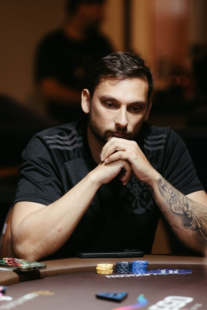 A poker player deep in thought during a game at a casino table, showcasing intensity and concentration.