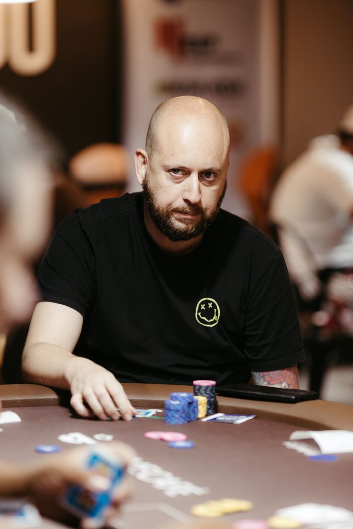 A poker player intently strategizes at an indoor table during a game.